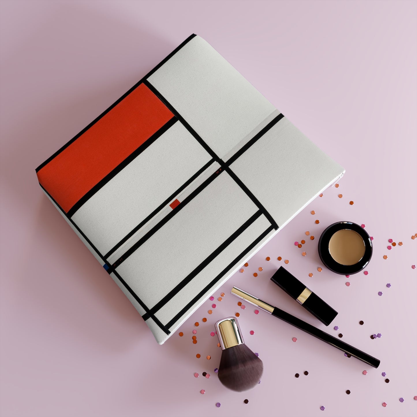 a pink background with a notebook, makeup and confetti