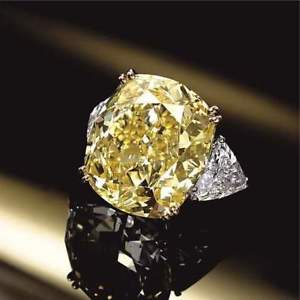 a fancy yellow created diamond ring sitting on top of a table