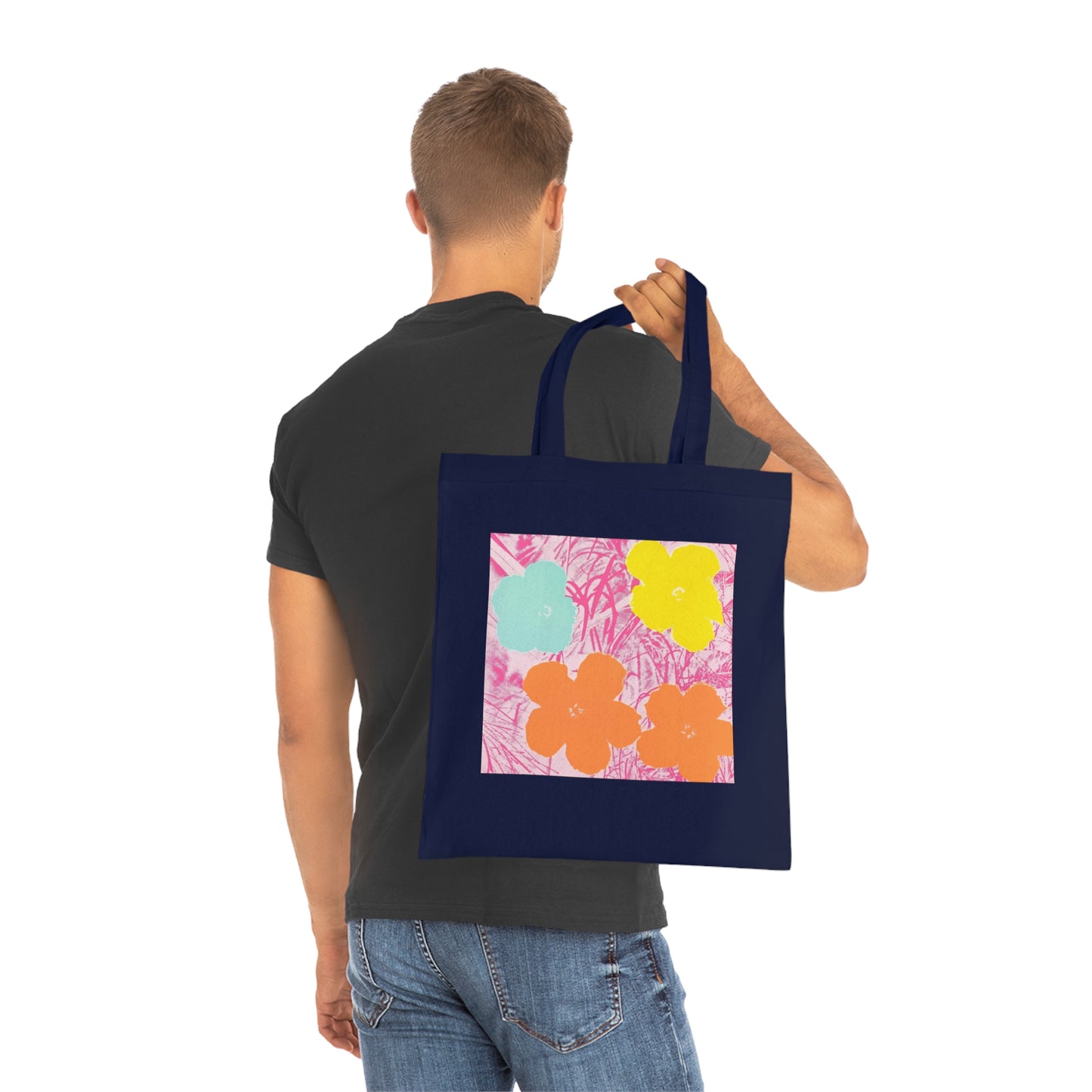 a man carrying a blue tote bag with a painting of flowers on it