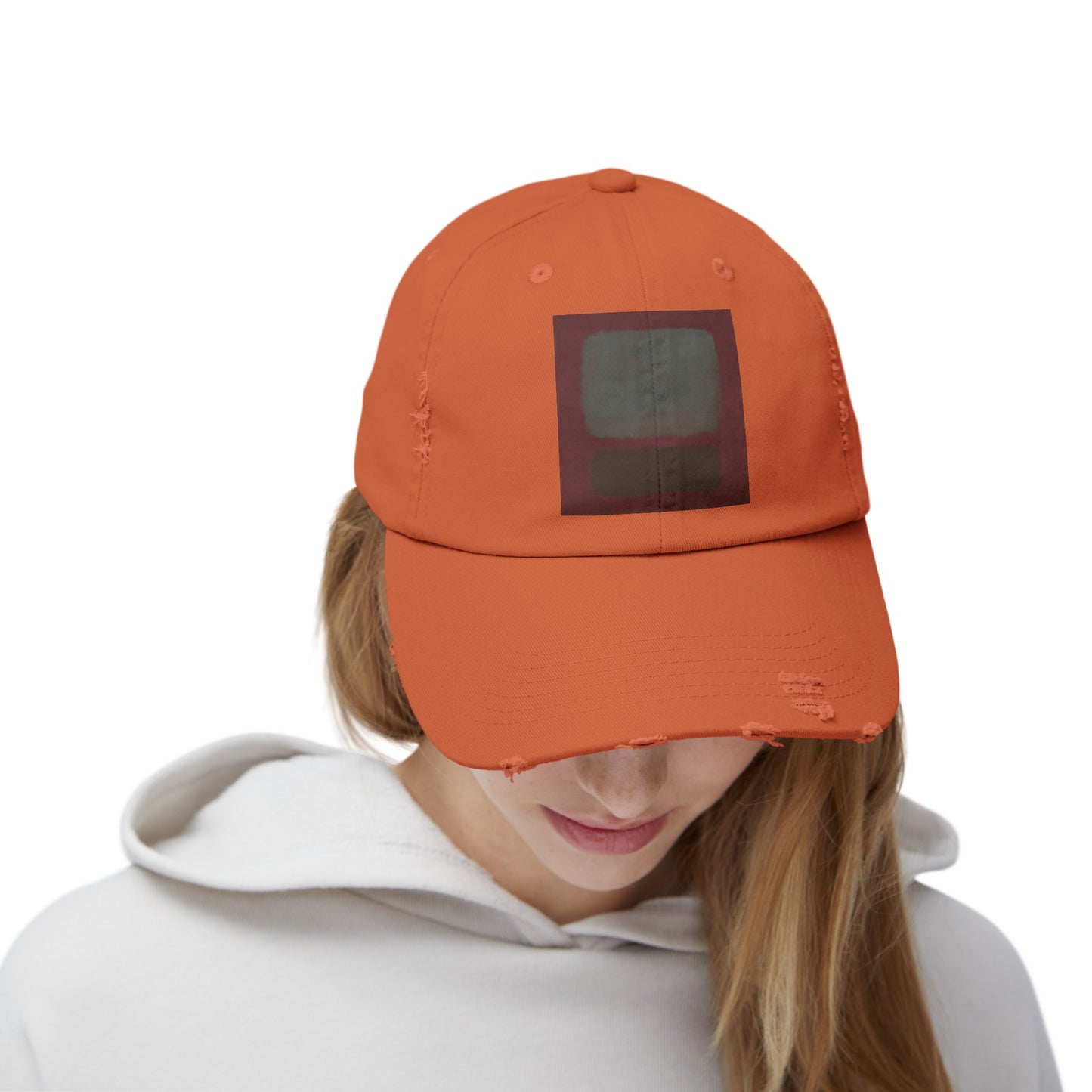 a woman wearing an orange hat with a black square on it