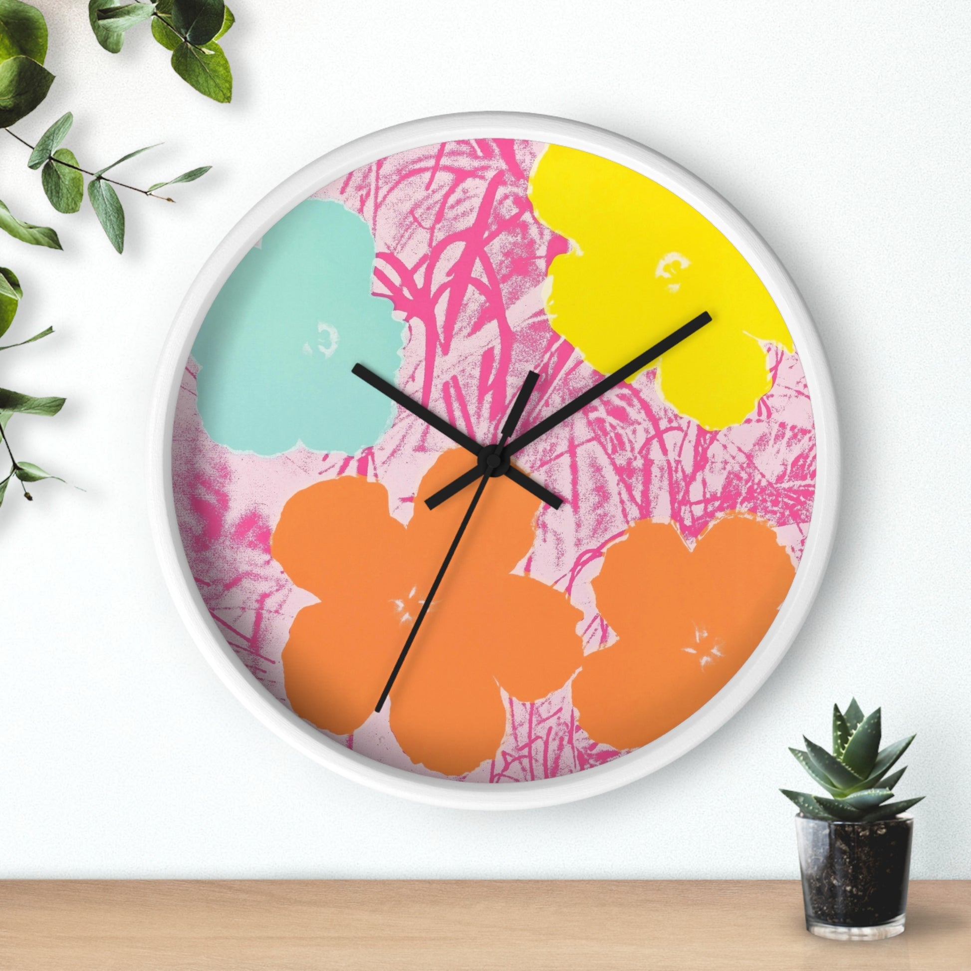 a clock that is on a wall next to a potted plant