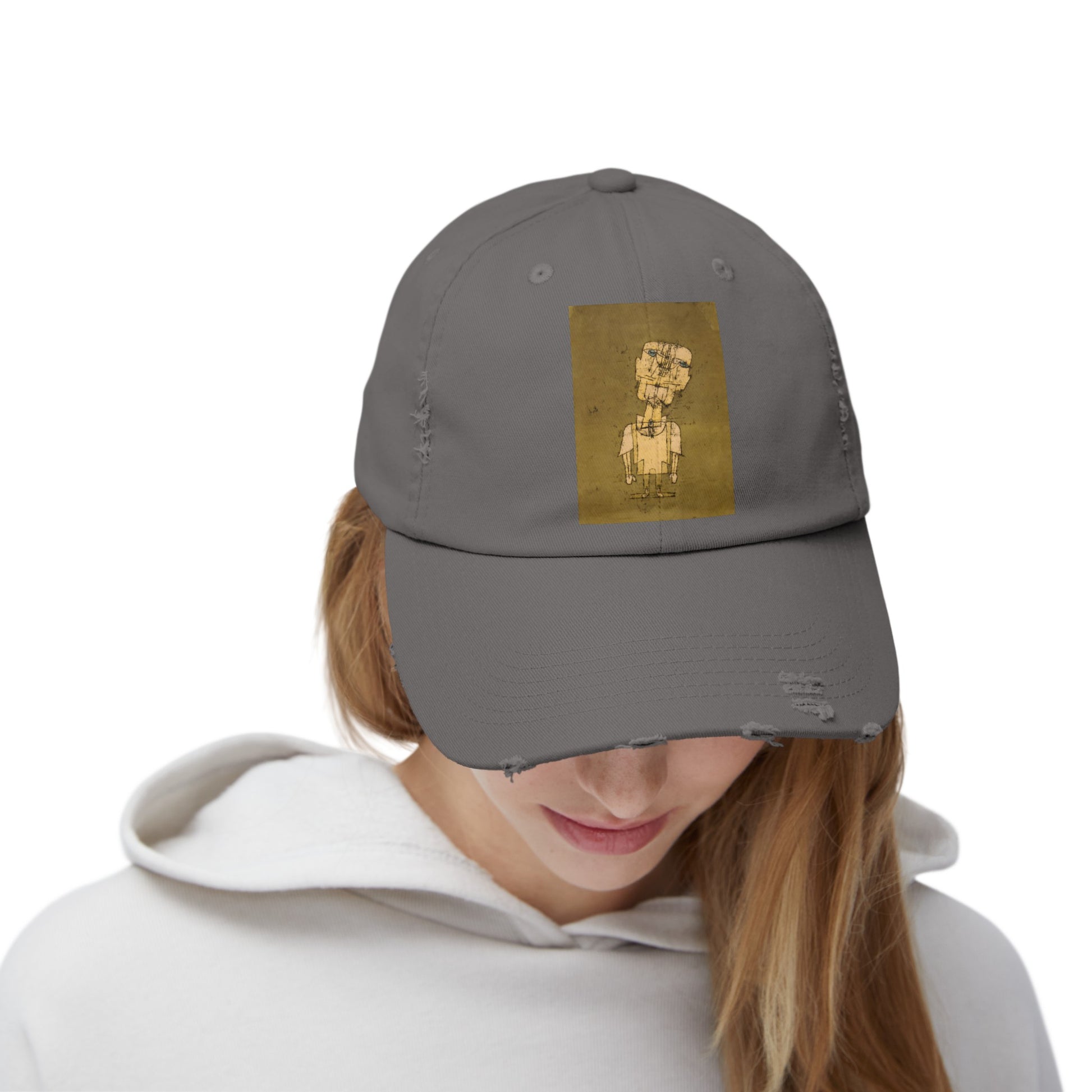 a woman wearing a gray hat with a gold design on it