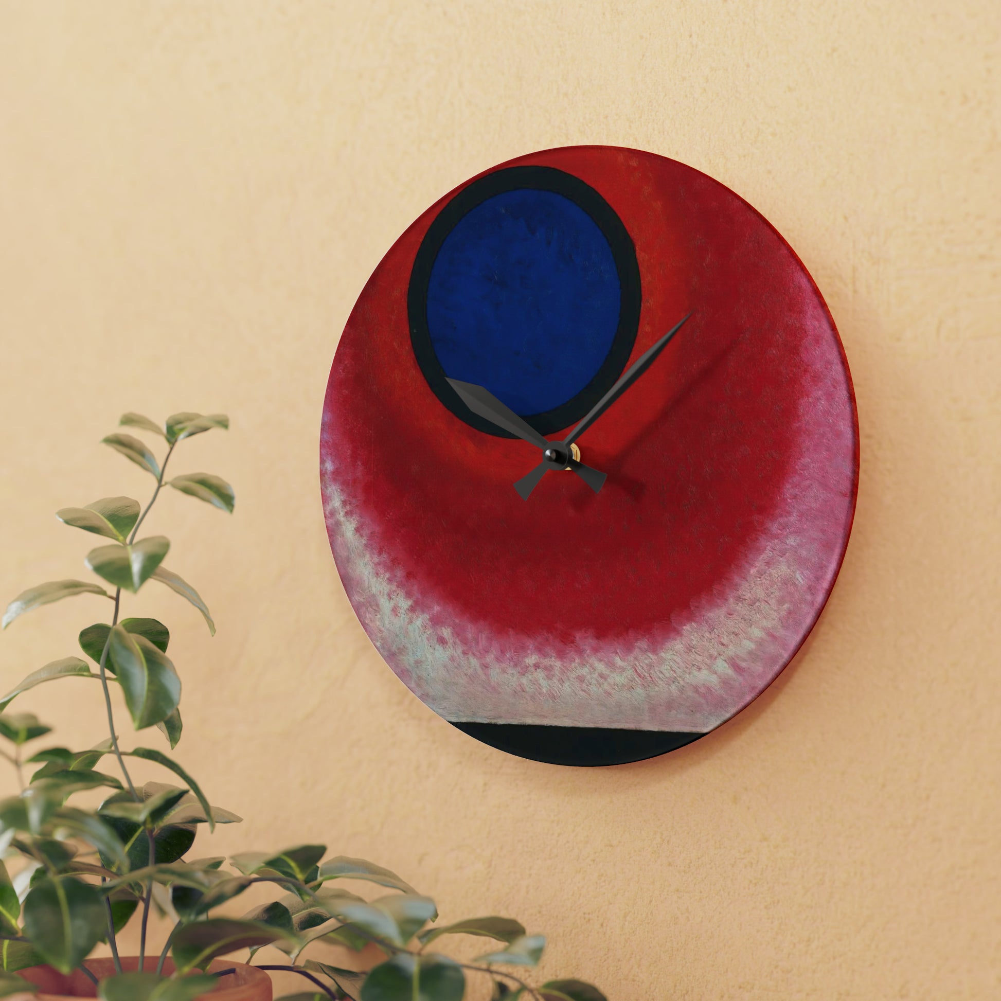 a red and blue clock on a wall next to a potted plant