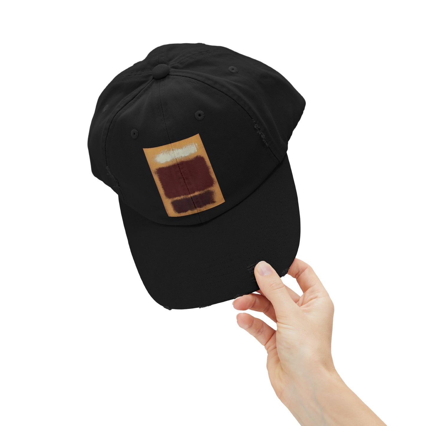 a hand holding a black hat with a patch on it