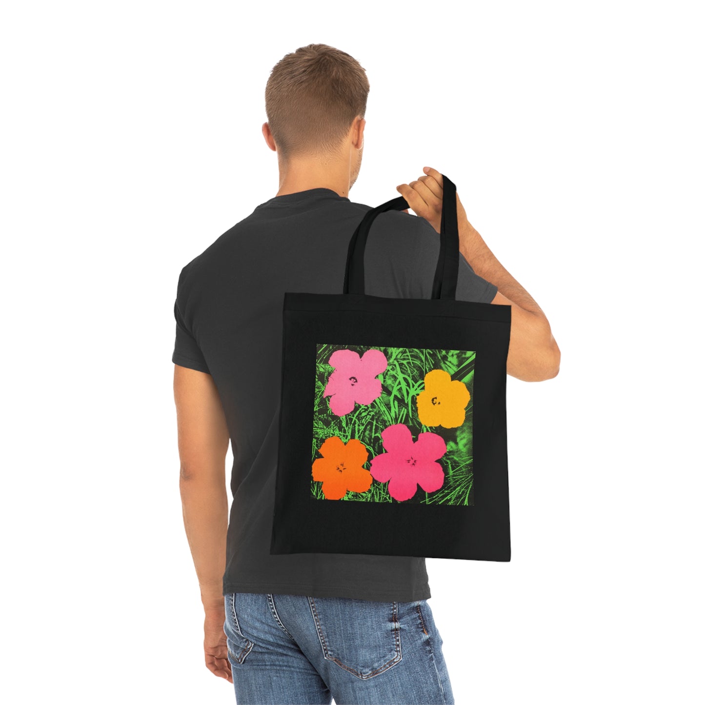 a man carrying a black tote bag with flowers on it