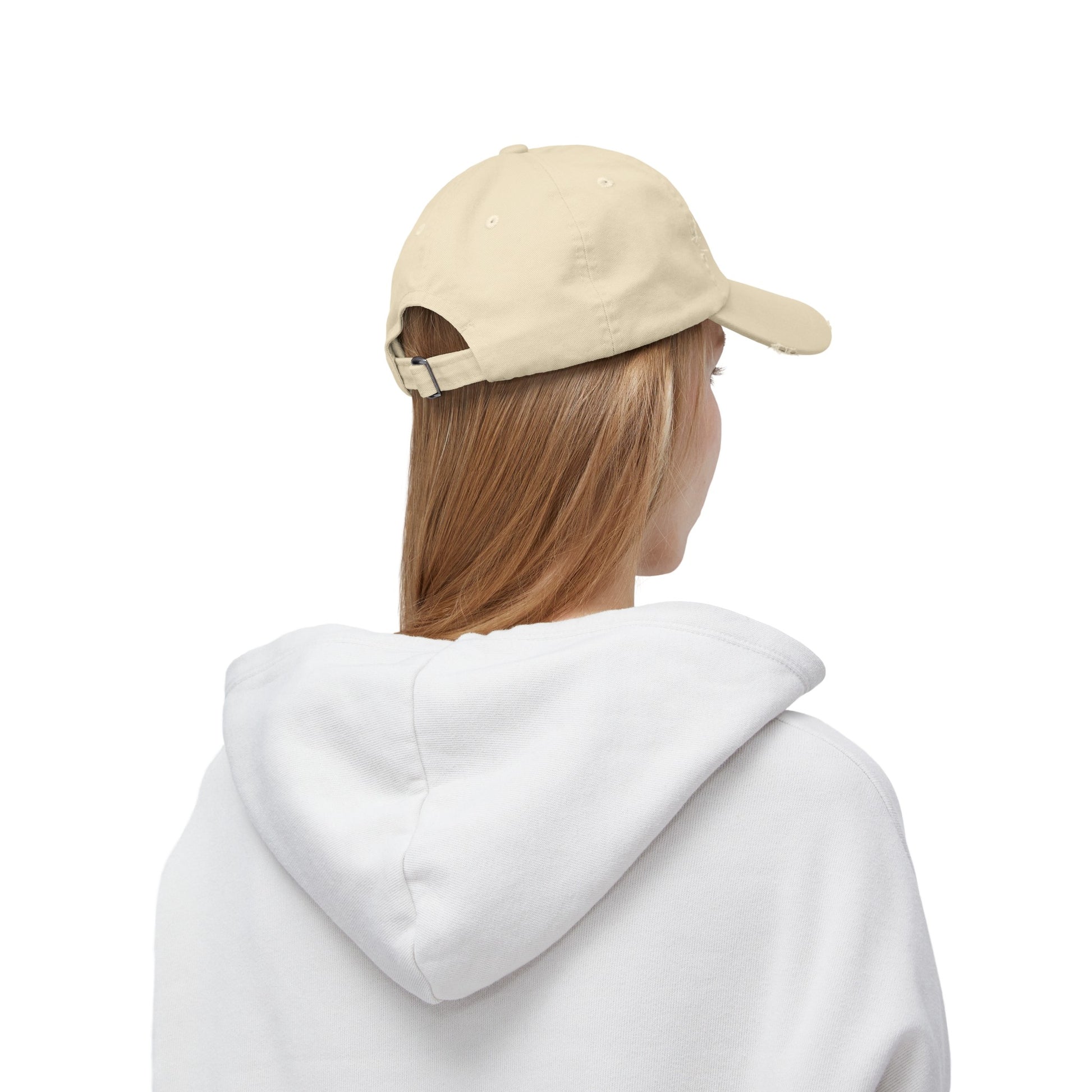 a woman wearing a white hoodie and a baseball cap