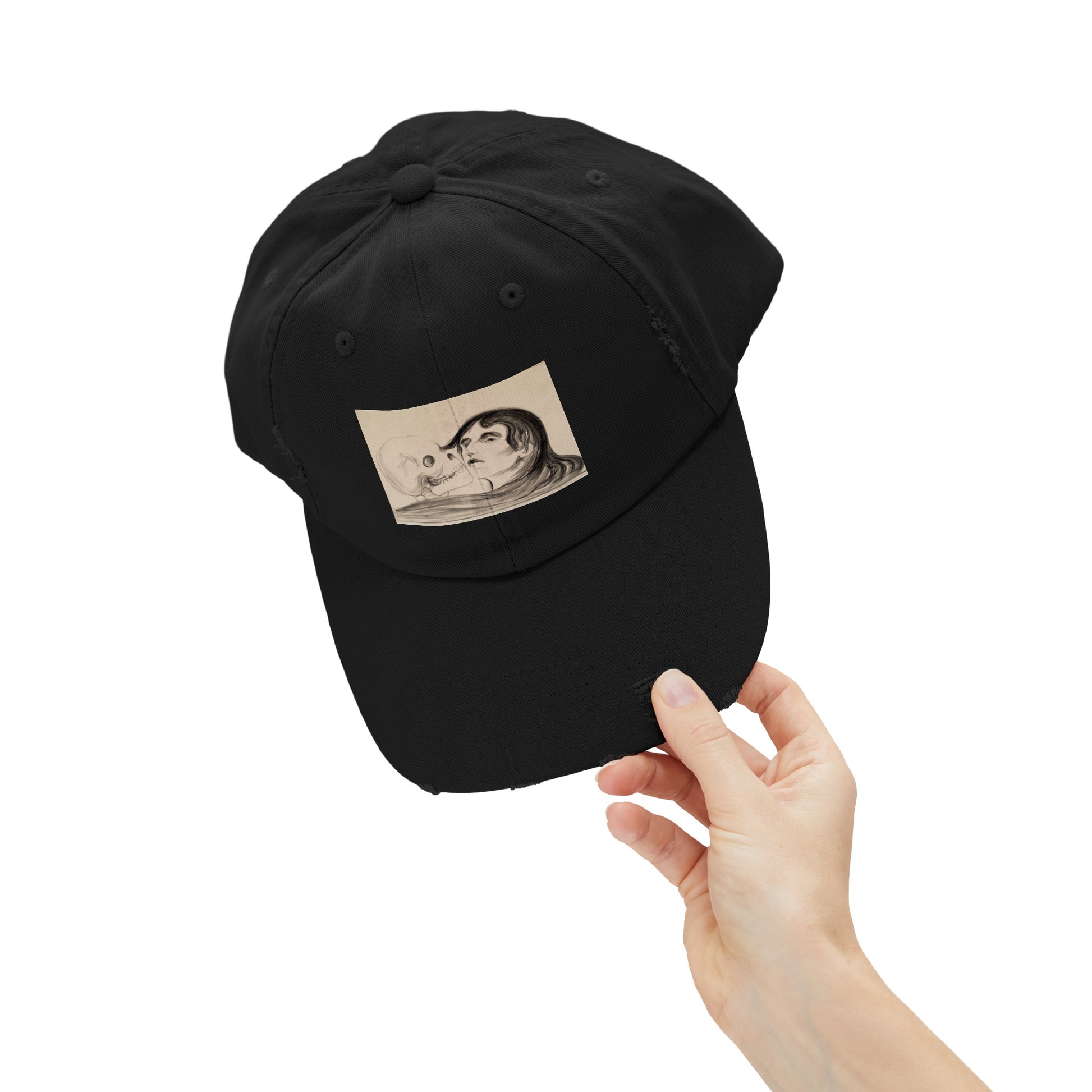 a hand holding a black hat with a picture of a man on it