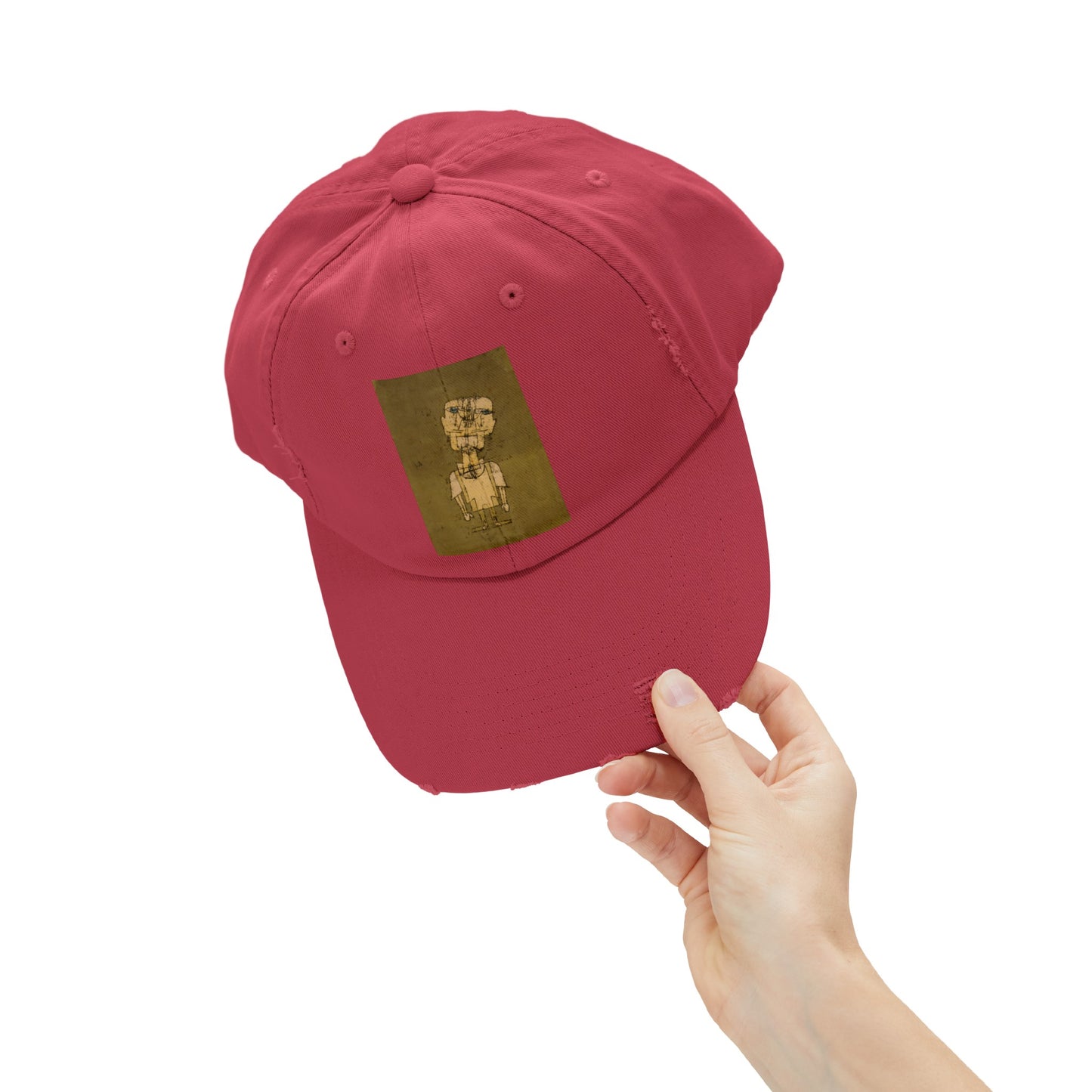 a hand holding a red hat with a picture of a dog on it