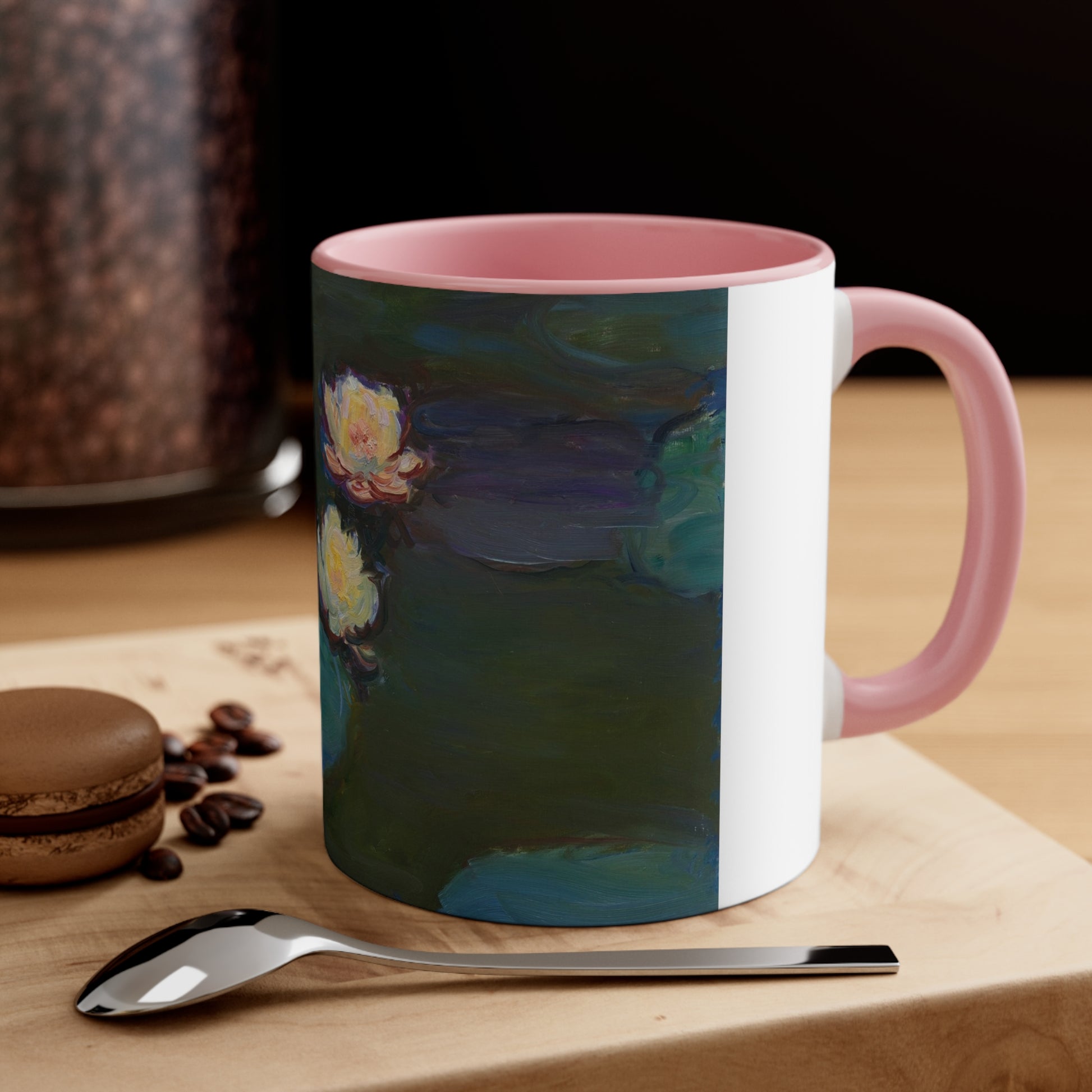 a pink and white coffee mug sitting on top of a wooden table