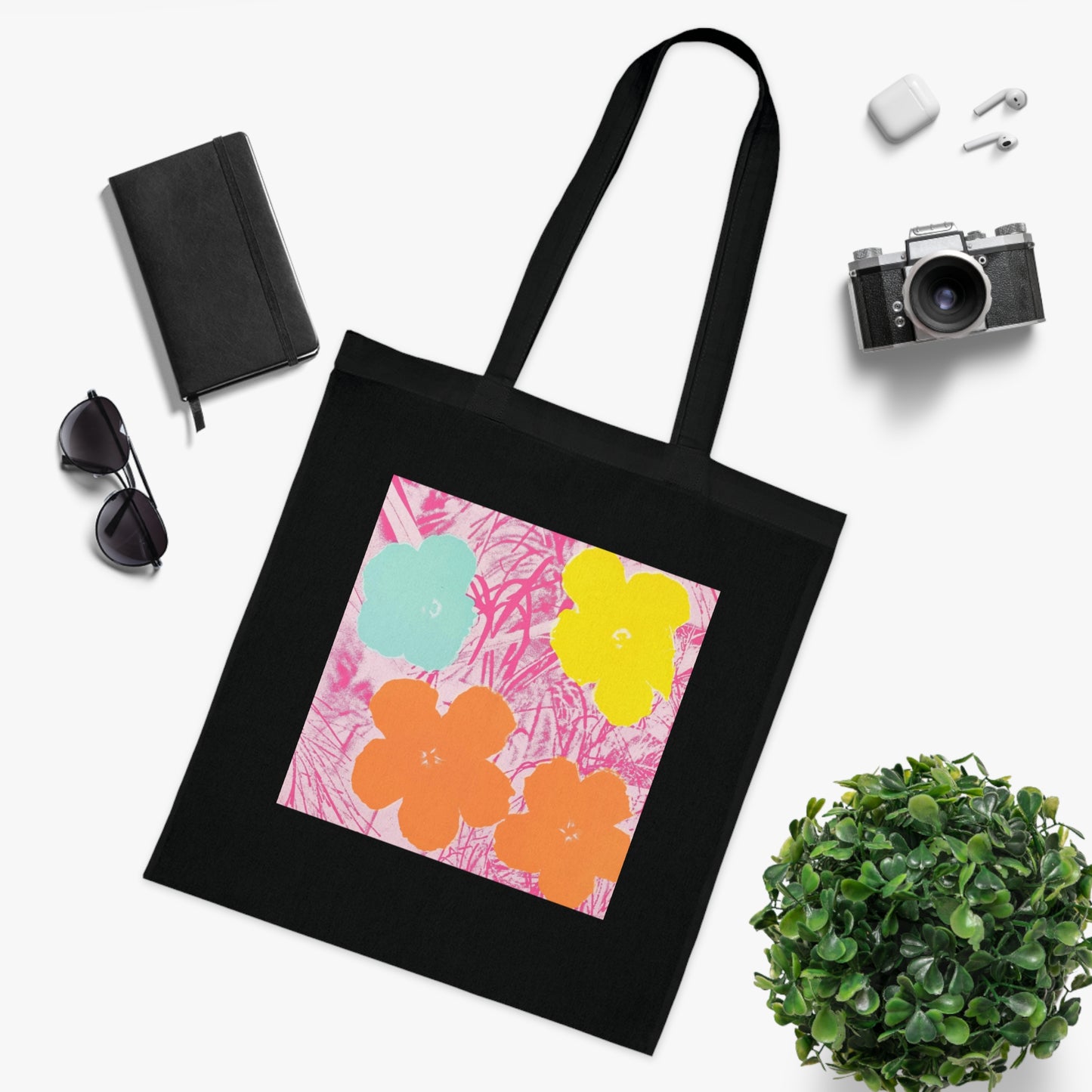 a black tote bag sitting on top of a table next to a plant