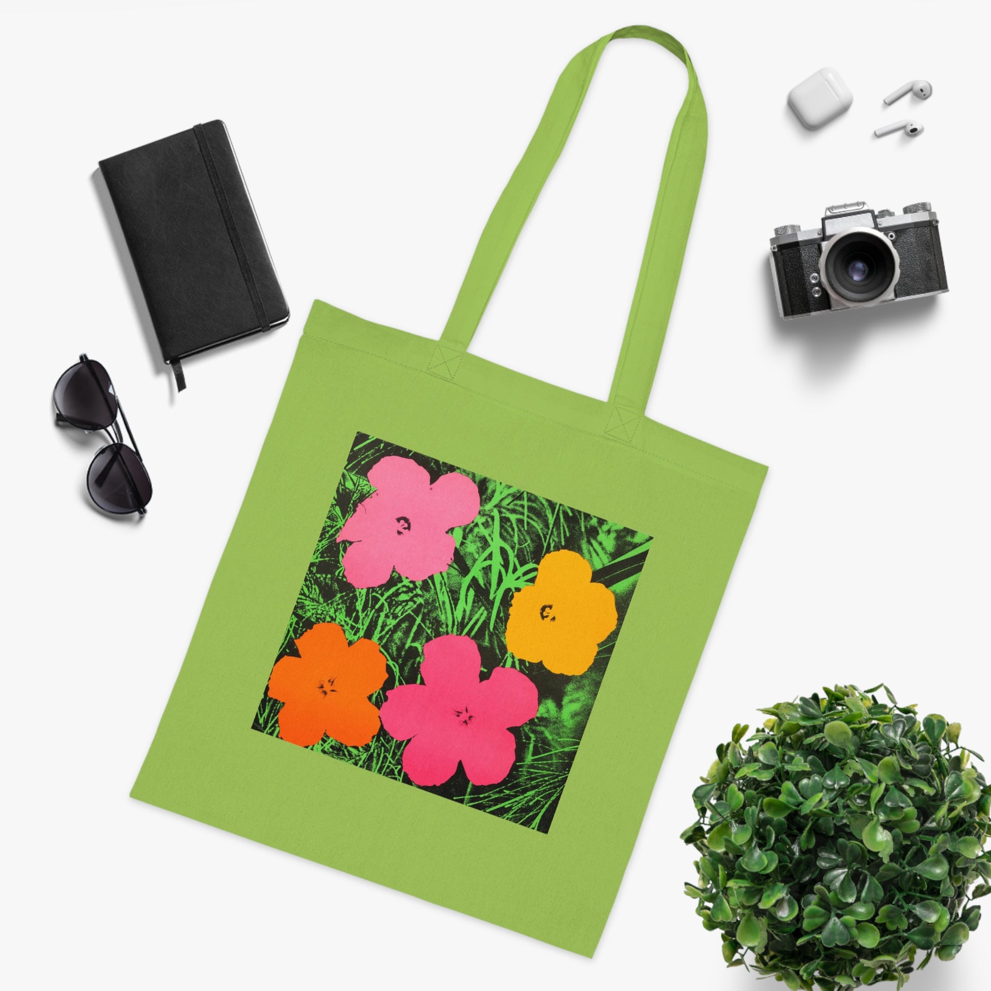 a green tote bag with a picture of flowers on it