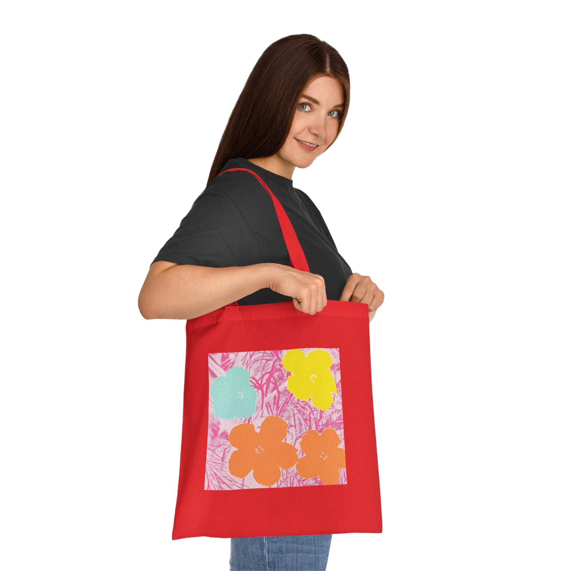 a woman holding a red tote bag with flowers on it