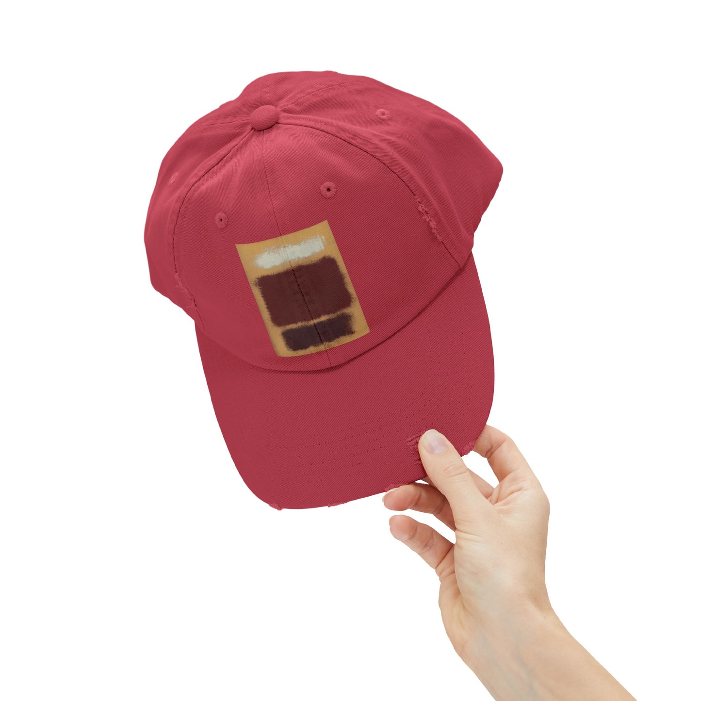 a person holding a red hat with a brown patch on it