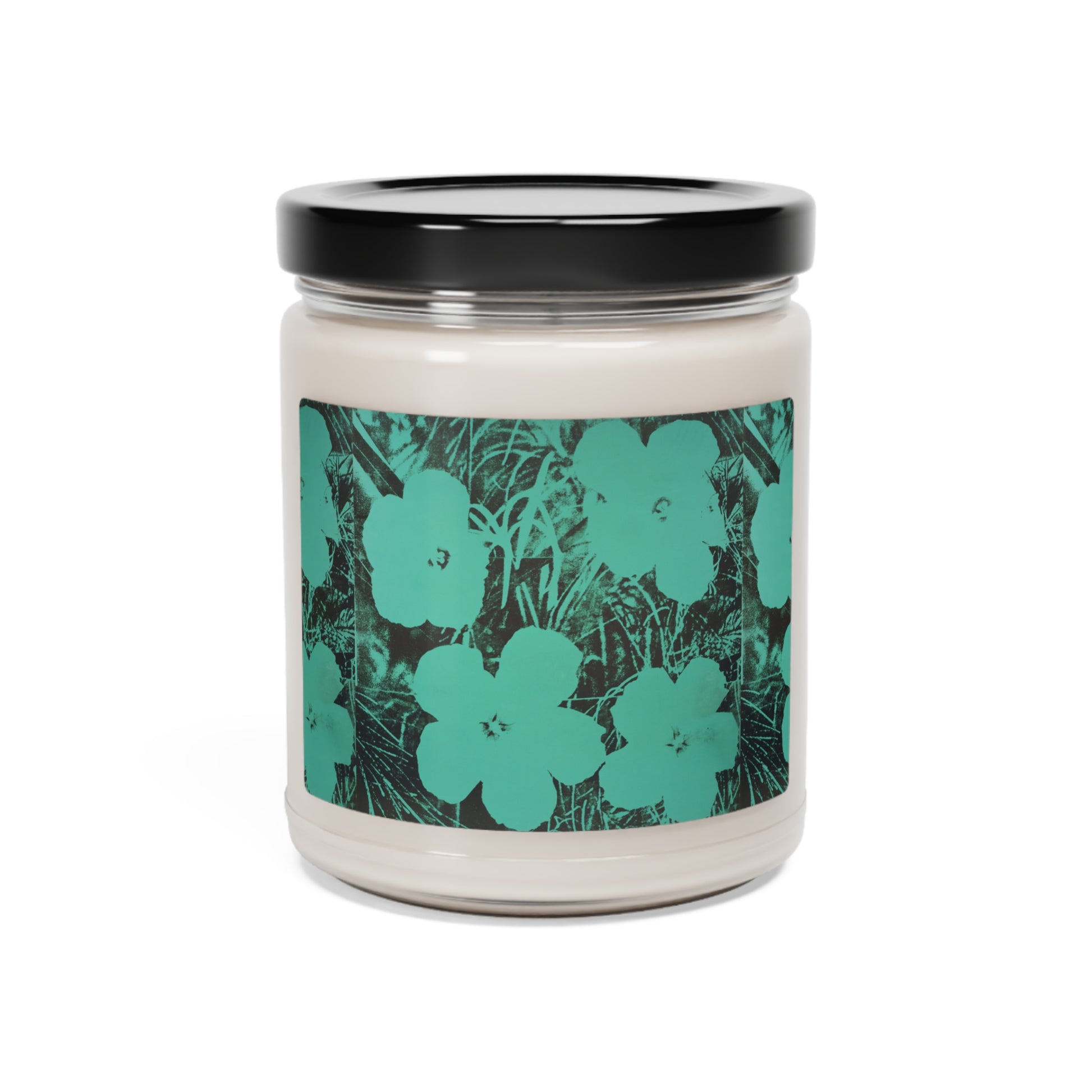 a candle with a green flower design on it