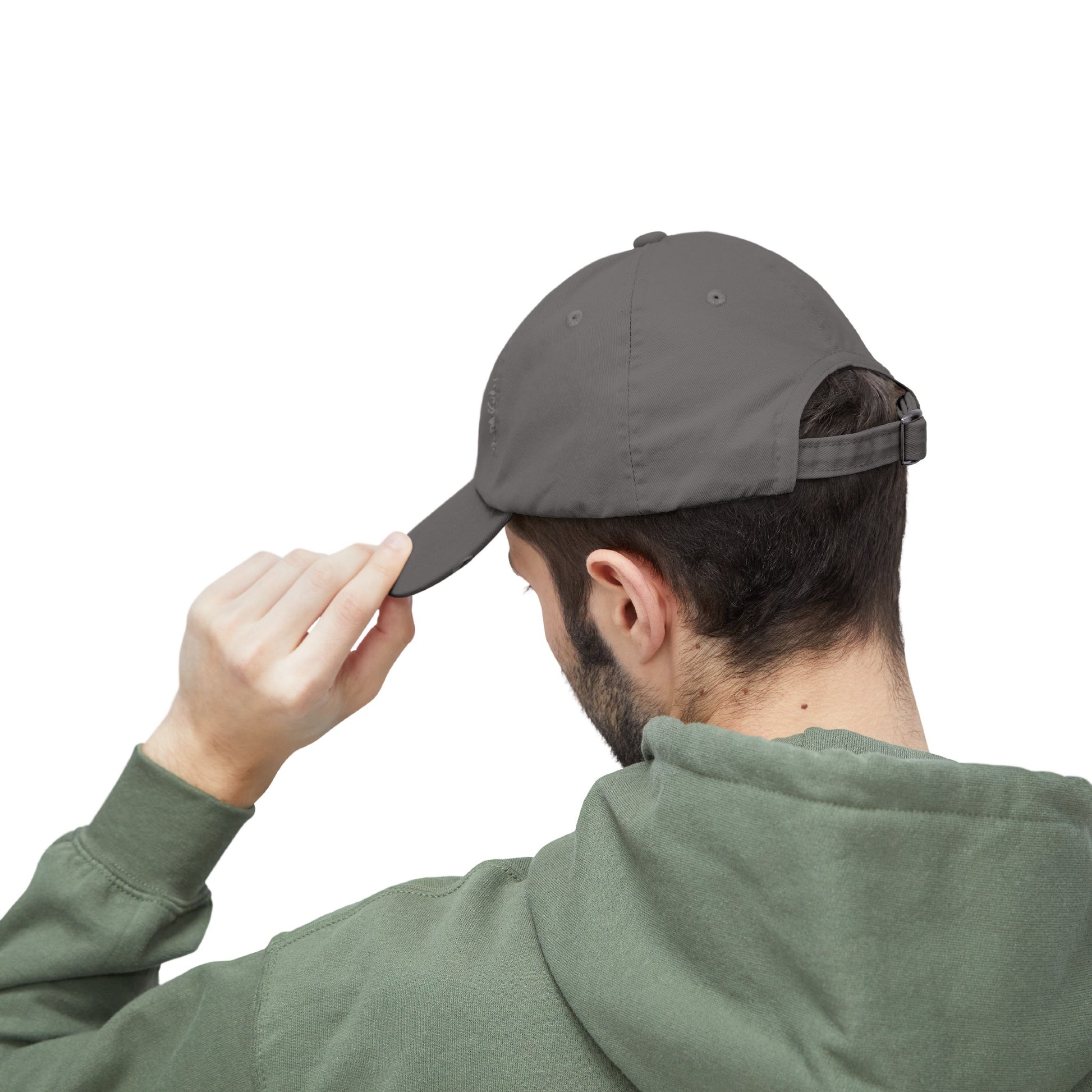 a man in a green hoodie putting a hat on his head