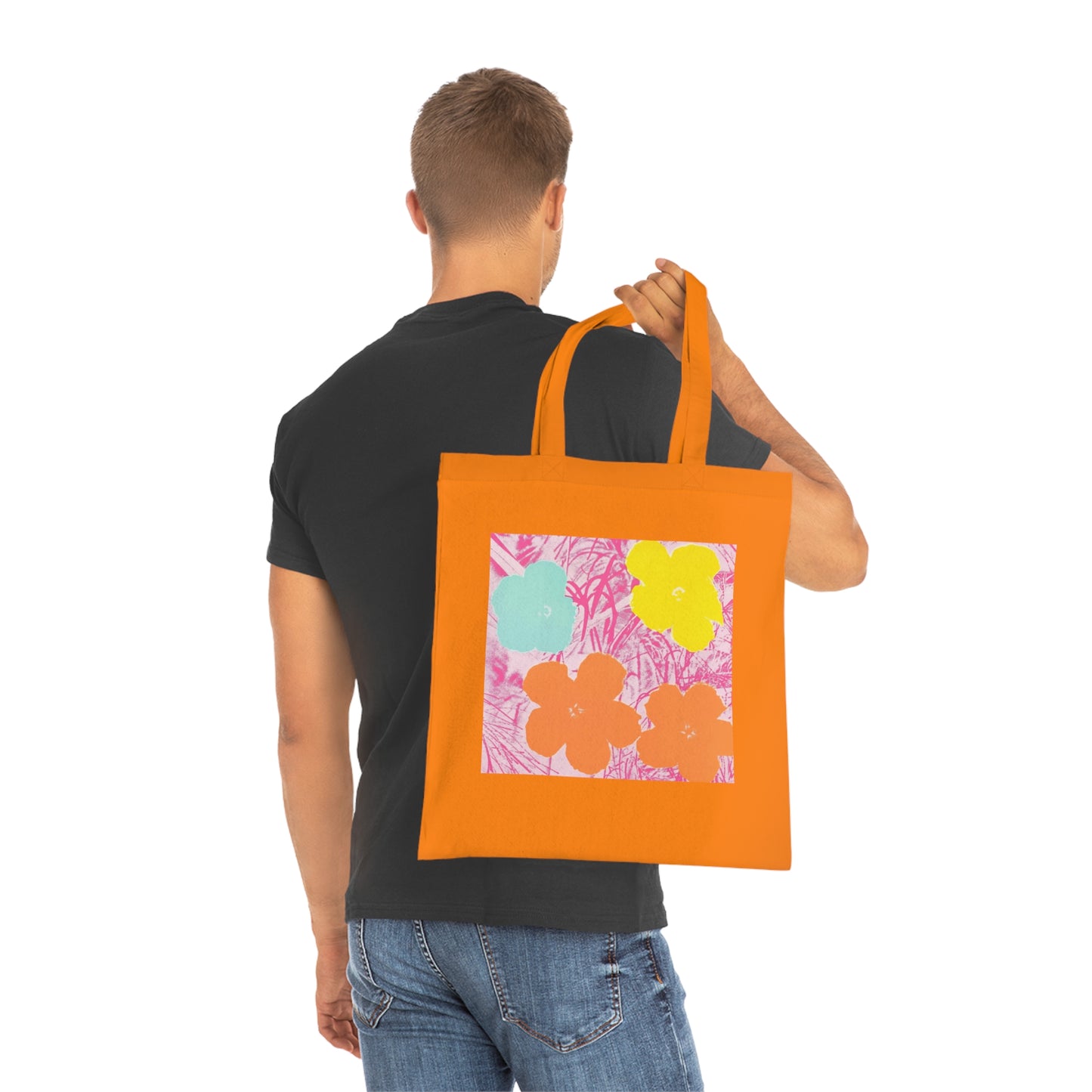 a man carrying an orange tote bag with flowers on it