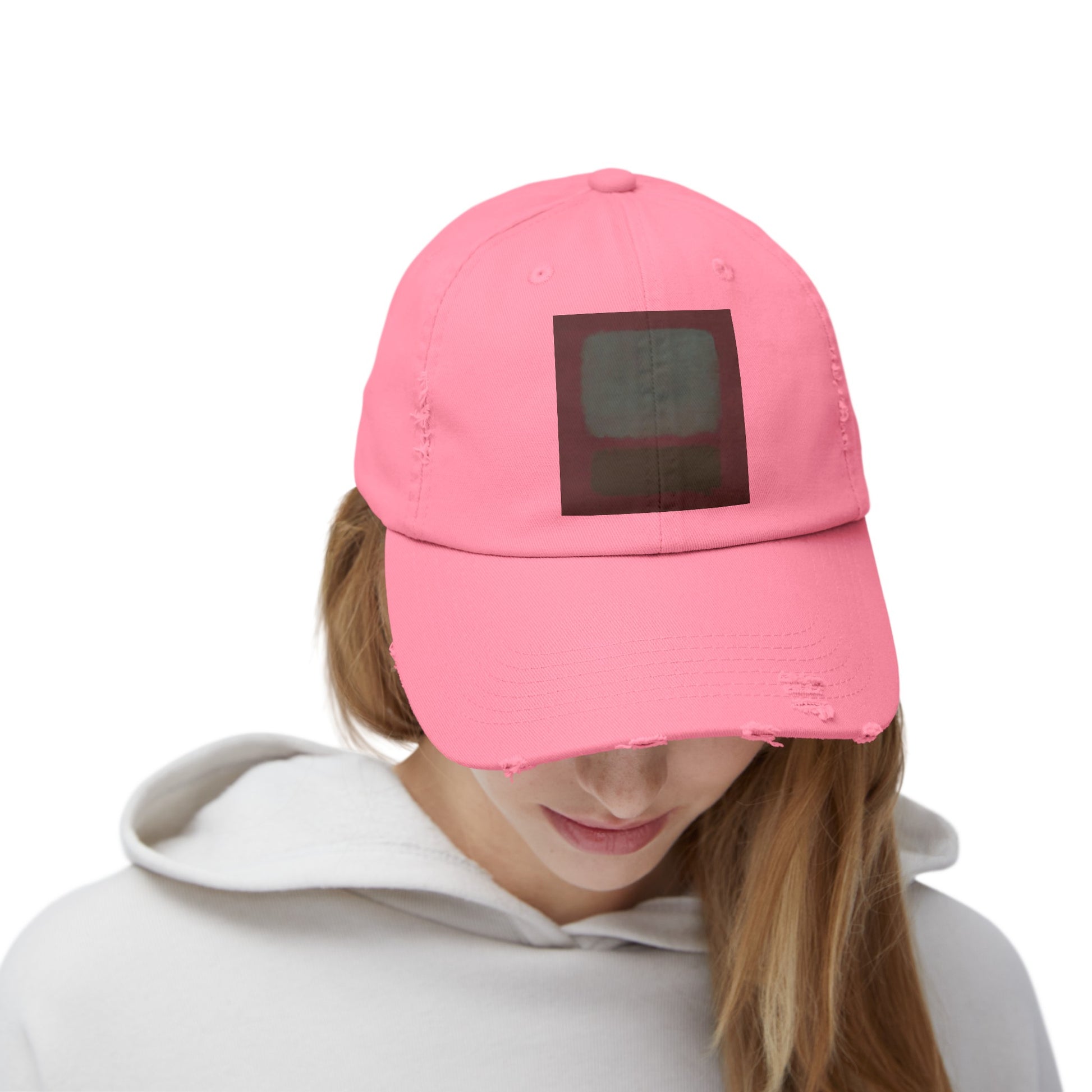 a woman wearing a pink hat with a black square on it