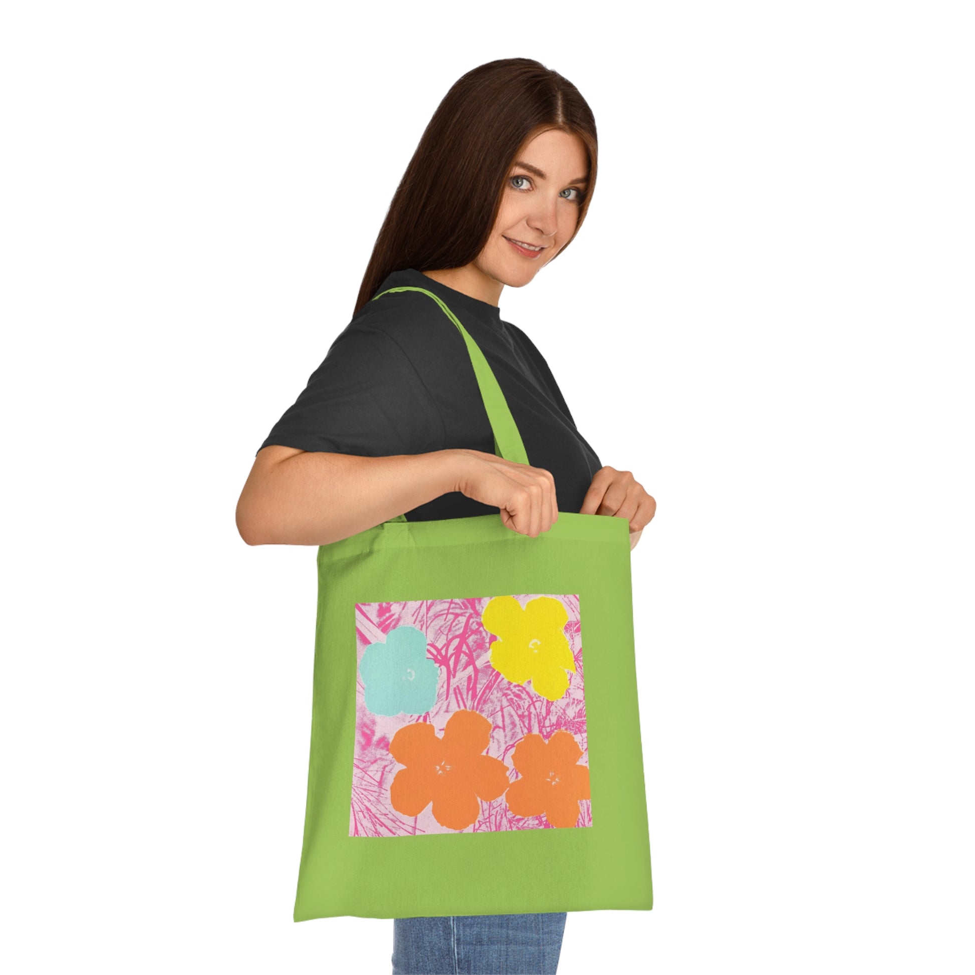 a woman holding a green tote bag with flowers on it