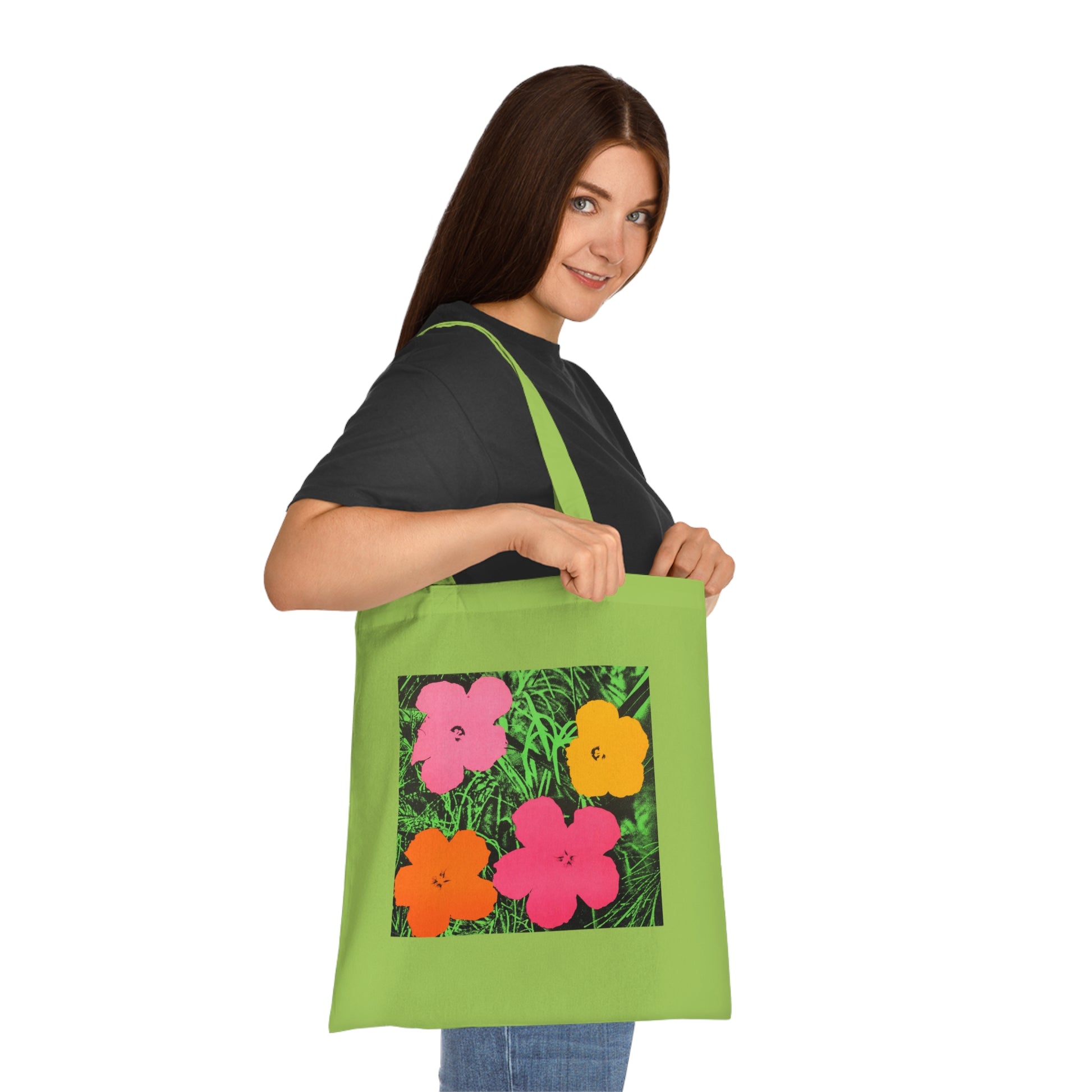 a woman holding a green bag with flowers on it