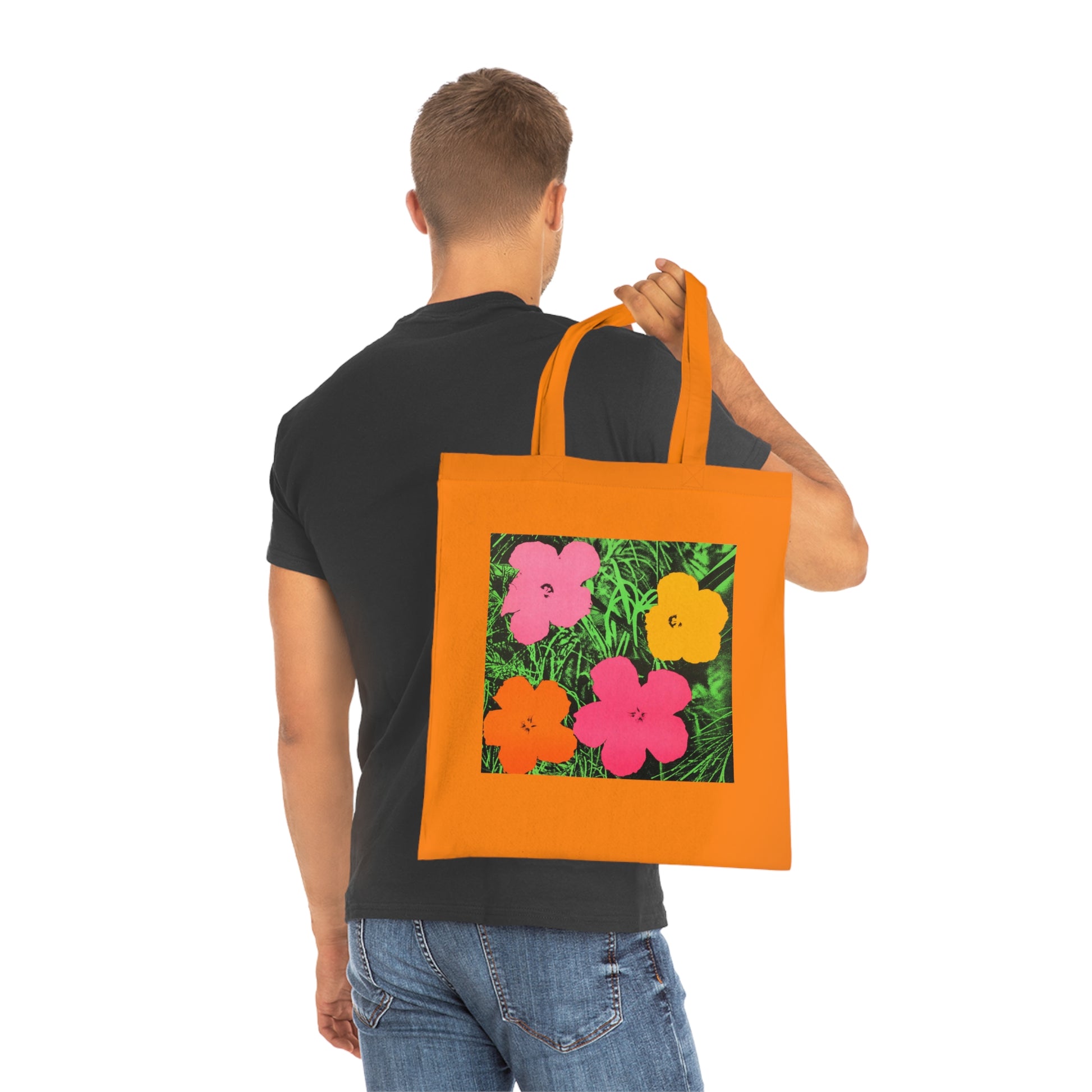 a man carrying an orange tote bag with flowers on it