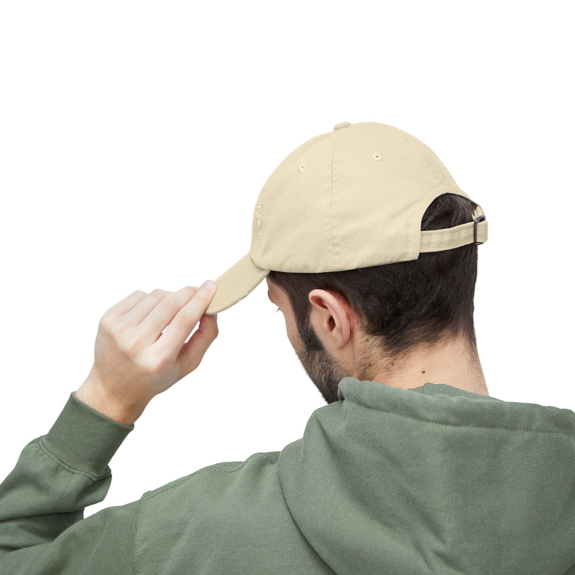 a man in a green hoodie is holding a baseball cap over his head