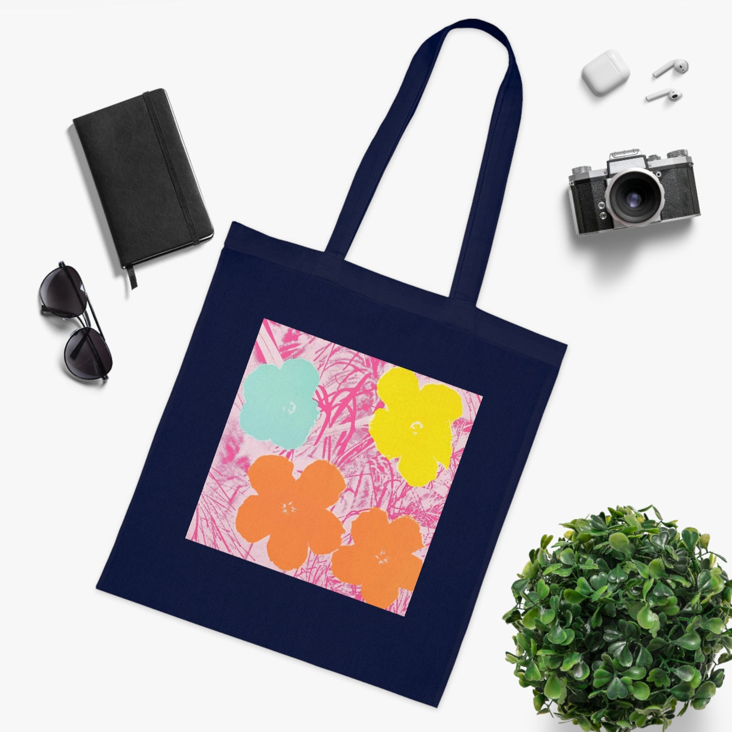 a tote bag sitting next to a potted plant