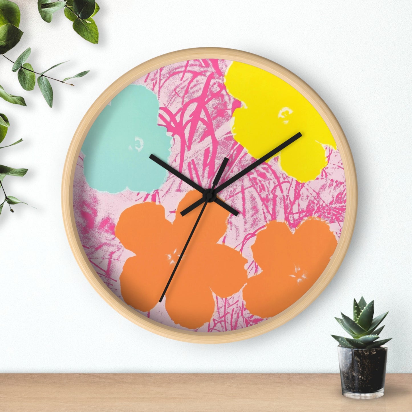 a clock that is on a wall next to a potted plant