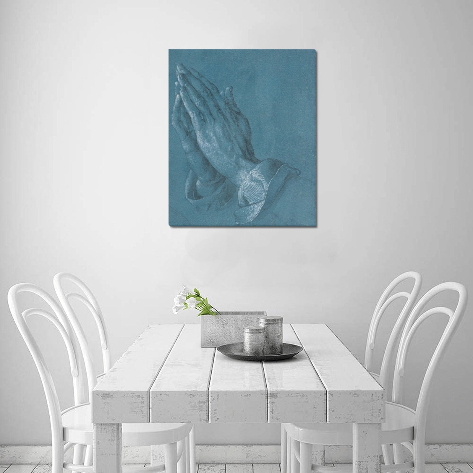 a painting of a praying hand on a wall above a table