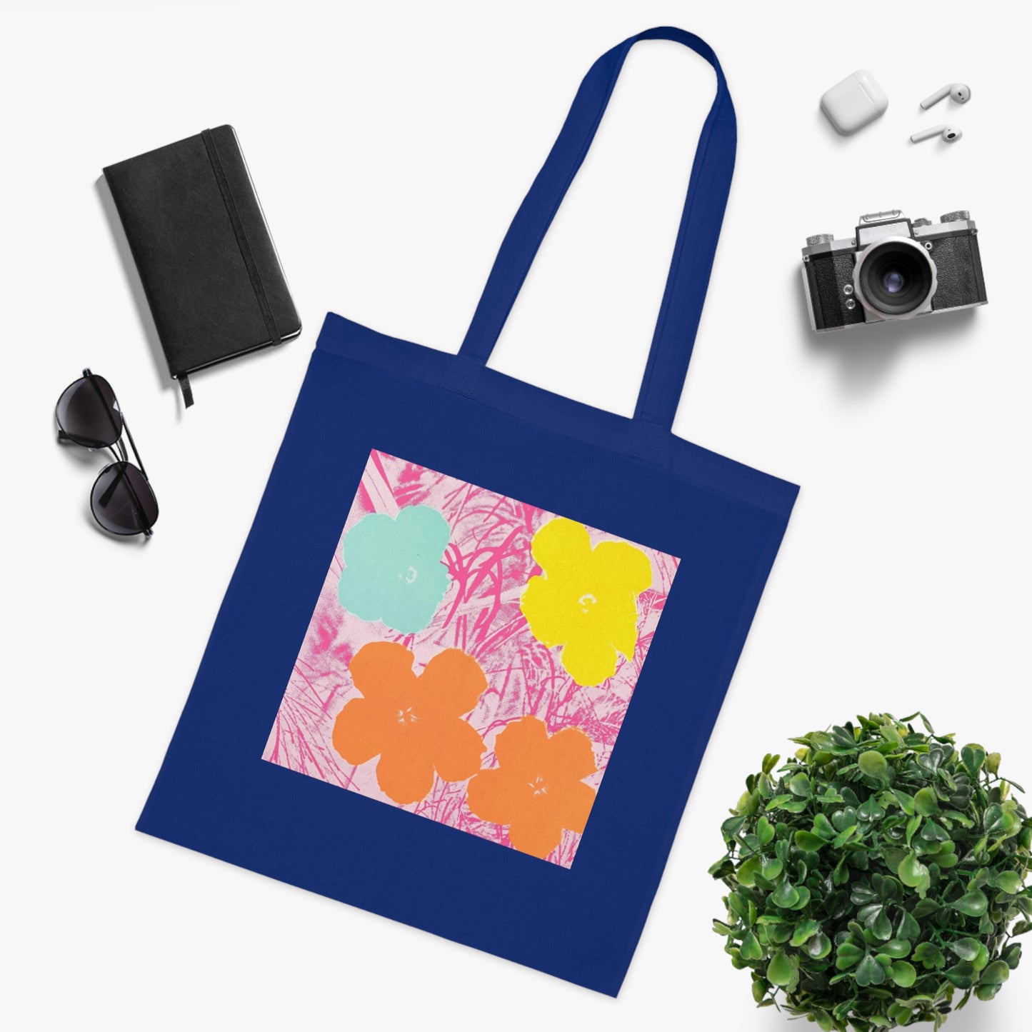 a blue tote bag sitting on top of a table next to a plant