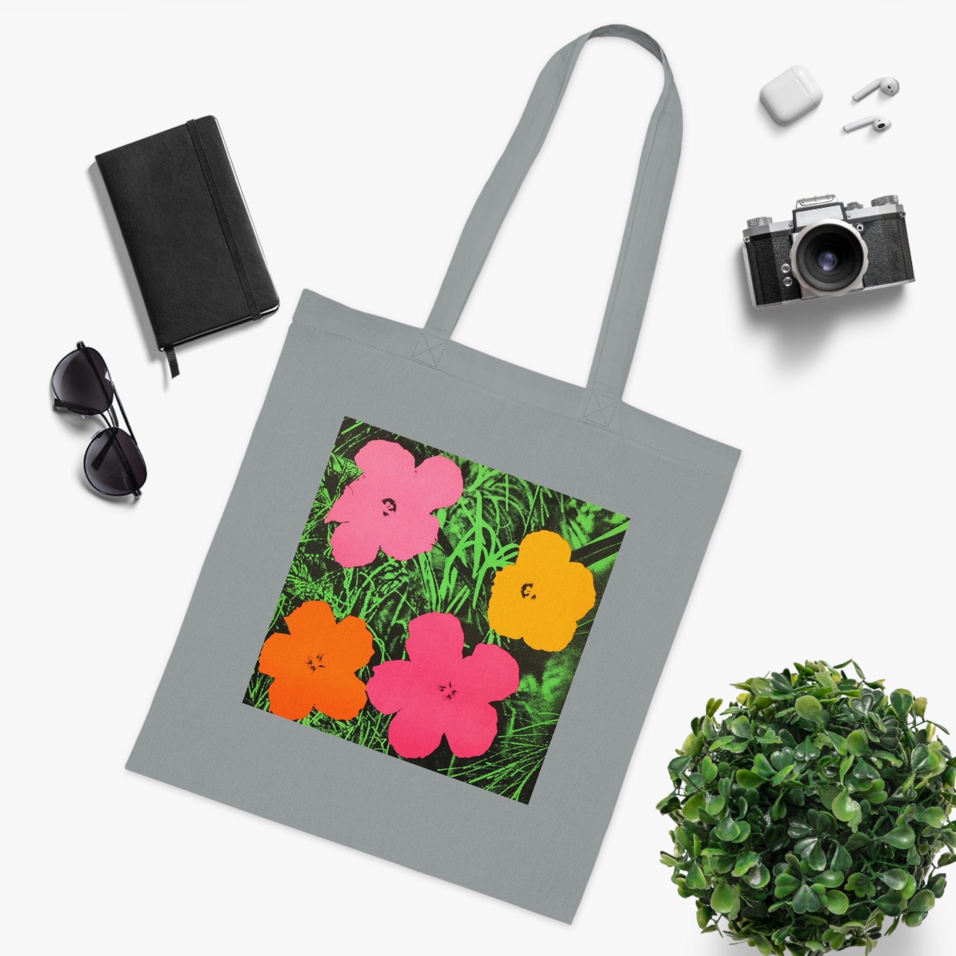 a tote bag sitting next to a potted plant