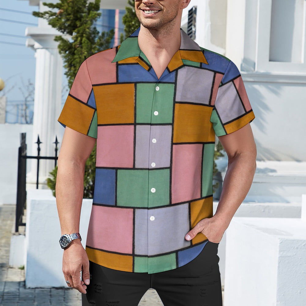 a man standing in front of a building wearing a colorful shirt